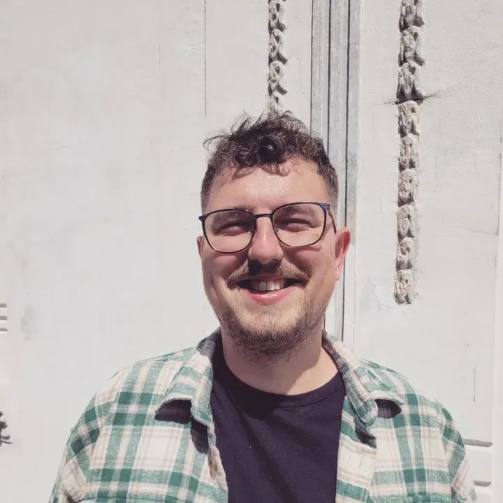 Toomas smiling in a green flannel shirt and glasses